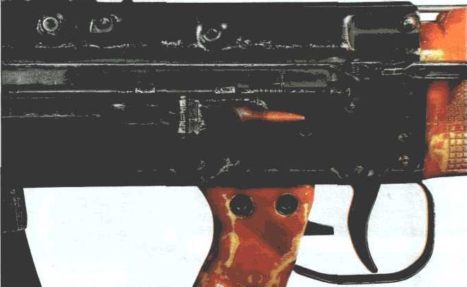 Удаление стреляной гильзы (или патрона при разряжании) из кожуха ствольной коробки производится через окно над рукояткой управления огнём, прикрытое подпружиненной крышкой 